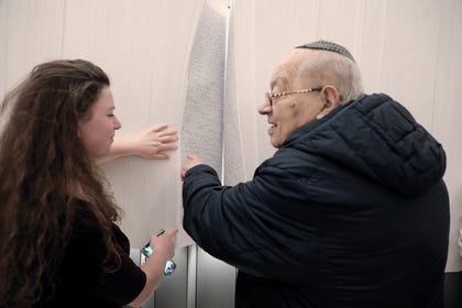 A Holocaust survivor finds the names of family members. Photo Yad Vashem