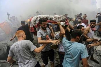 Persone trasportano il corpo di un palestinese ucciso lunedì negli attacchi israeliani nel campo profughi di Jabalia, nel nord della Striscia di Gaza.