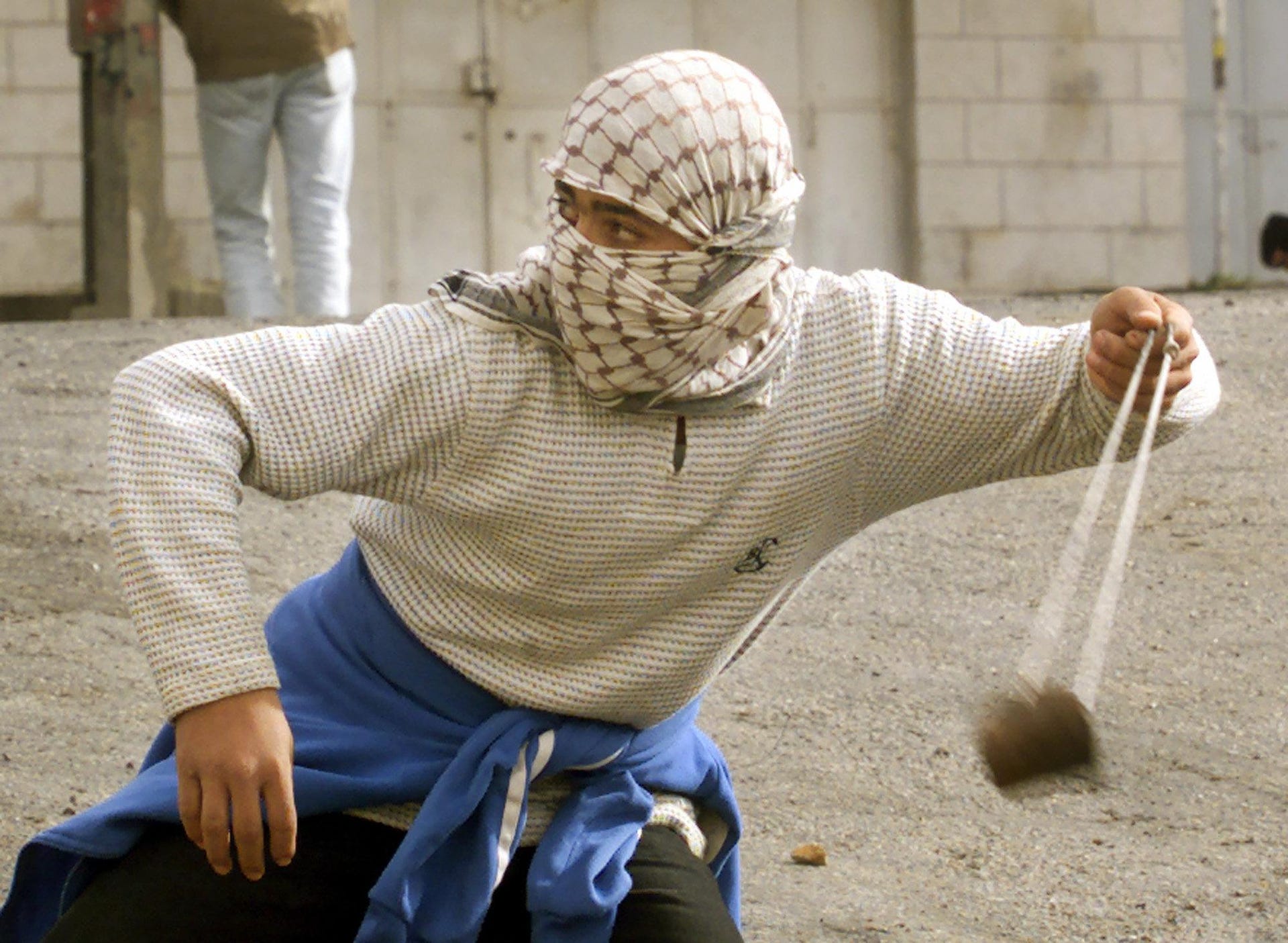 Un palestinese lancia una pietra a Ramallah durante la seconda Intifada, nel 2000.