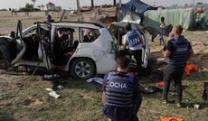 UN staff members inspecting a car used by World Central Kitchen aid workers that was hit by an Israeli strike in central Gaza.
