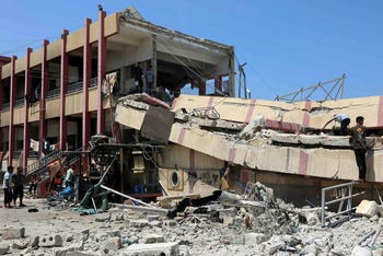 La gente inspecciona los daños después de un ataque israelí contra una escuela que alberga a palestinos desplazados en la ciudad de Gaza el martes.