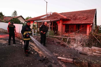 Las fuerzas de seguridad y los bomberos israelíes se reúnen cerca de una casa que fue dañada por un cohete disparado desde el Líbano, en la ciudad de Rosh Pina, en la Alta Galilea, el jueves.