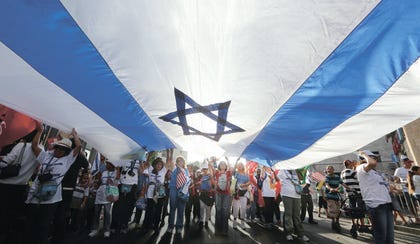A group of Christians stand under an Israeli flag at a Sukkot march. Credit: Ashernet A group of Christians stand under an Israeli flag at a Sukkot march