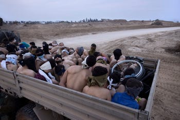 Detenuti palestinesi seduti sul retro di un camion a Gaza, nel 2023.