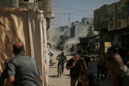 Palestinians run for cover during an Israeli military strike on a building in Gaza City, Saturday.