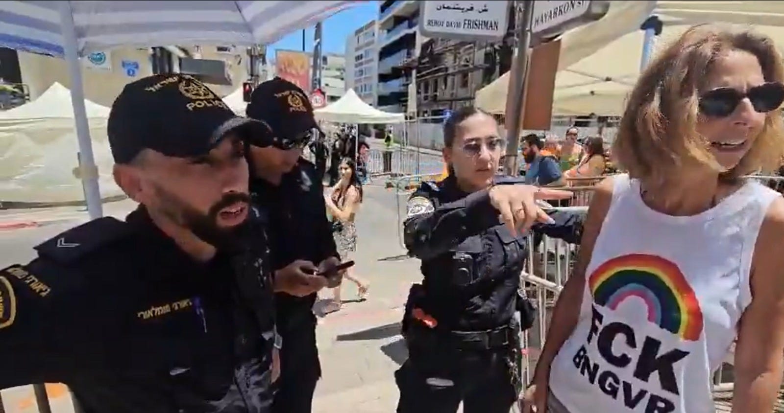 Police block a woman with a "FCK BNGVR" shirt from entering the Tel Aviv pride parade, Friday.