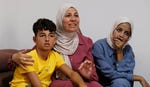 Hiam al-Najjar with her children Bilal (left) and Rimas. The two have been living in a refugee camp in Khan Yunis, without parents, without electricity or water, under relentless aerial bombings.