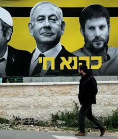 An election poster featuring Itamar Ben-Gvir (left), Benjamin Netanyahu and Bezalel Smotrich, 2019. The poster reads "Kahane lives," in reference to extremist rabbi Meir Kahane, who founded the radical Kach party. Kahane was banned from Israeli politics in 1988. Credit: Thomas Coex/AFP An election poster featuring Itamar Ben-Gvir (left), Benjamin Netanyahu and Bezalel Smotrich, 2019. The poster reads "Kahane lives," in reference to extremist rabbi Meir Kahane, who founded the radical Kach party. Kahane was banned from Israeli politics in 1988.