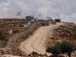 A Palestinian lies paralyzed, while the settler who shot him remains on the hill