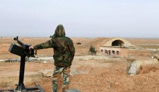 A member of Syrian government forces stands guard at the Abu Duhur military air base area in Idlib province in 2018.