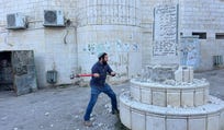 Far-right lawmaker Tzvi Succot smashing a Palestinian monument Tuesday in the West Bank under the protection of Israeli soldiers and the Border Police.