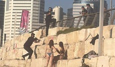 A guard in Prime Minister Benjamin Netanyahu's security team seen drawing his gun while clearing a Tel Aviv beach before the prime minister arrives.