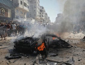 Palestinians gather around the site of an Israeli strike in Gaza City, on Monday.