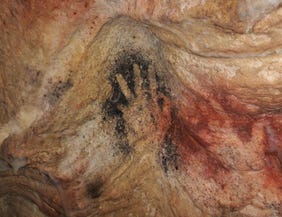 A hand stencil in the Gargas caves. The site contains 231 hand stencils in various colors and sizes, most missing one or more fingers. Researchers suspect they represent some kind of code.