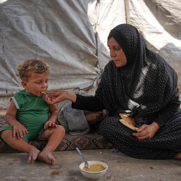 A woman feeding a child with a meal cooked using combustible materials collected from a garbage dump amid a shortage of cooking gas in Deir al-Balah, central Gaza, on August 22. Credit: Abdel Kareem Hana/AP A woman feeding a child with a meal cooked using combustible materials collected from a garbage dump amid a shortage of cooking gas in Deir al-Balah, central Gaza, on August 22.