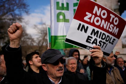 A protestor holding a sign reading "No to Zionism in the Middle East" during a rally against U.S. and Israeli strikes on Iran, in Istanbul, Turkey, in March. Credit: Emrah Gurel/AP A protestor holding a sign reading "No to Zionism in the Middle East" during a rally against U.S. and Israeli strikes on Iran, in Istanbul, Turkey, in March.