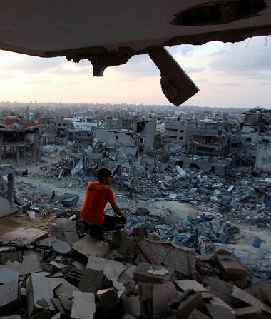 A boy observing a destroyed neighborhood in Gaza after the 2014 Gaza war.