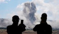 People from Mansouri record the smoke billowing from an Israeli-controlled detonation destroying their village, as seen from Hanniyeh village, southern Lebanon, Friday.