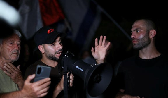 Right-wing agitator Mordechai David speaks through a megaphone at a demonstration outside the house of "NAZA" film co-director Rachel Szor's parents, Wednesday.