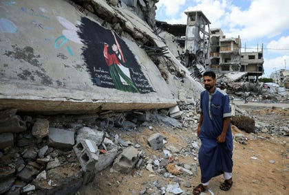 A Palestinian walks past a mural painted in honour of American rapper Macklemore, amid buildings destroyed during the war, in Gaza City, Friday.