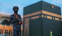 A soldier from Yemen's Houthi rebels stands in front of a giant banner of the Kaaba, during a rally to protest Saudi Arabia's accusation that the Houthis targeted Islam's holiest site in Sanaa, Yemen, Friday, Sept. 18, 2026.