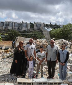 משפחת עודה לצד ביתם ההרוס, ברקע ההתנחלות ראש צורים ואלון שבות. צילום: מנחם כהנא משפחת עודה לצד ביתם ההרוס, ברקע ההתנחלות ראש צורים ואלון שבות