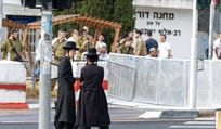 Ultra-Orthodox men gather outside an IDF recruitment office in central Israel in August.