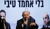 Benjamin Netanyahu at a Likud election conference, 2020. A screen behind him reads, "Without Ahmad Tibi."