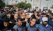 Palestinians carry the body of journalist Hassan Eslaiah in Khan Yunis, May 2025.