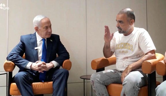 Prime Minister Benjamin Netanyahu meets Yaniv Hayun, a passenger on the flydubai flight bound for Israel from the UAE, at Ben-Gurion Airport, Wednesday.