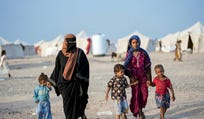 Women and children, who fled fighting between the Houthis and government forces in Red Sea coastline areas, walk at a camp for internally displaced people near Aden, Yemen, September.