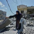 Hanan Qubaisi collects belongings from her house destroyed in previous Israeli airstrikes in Nabatiyeh, southern Lebanon, in June.