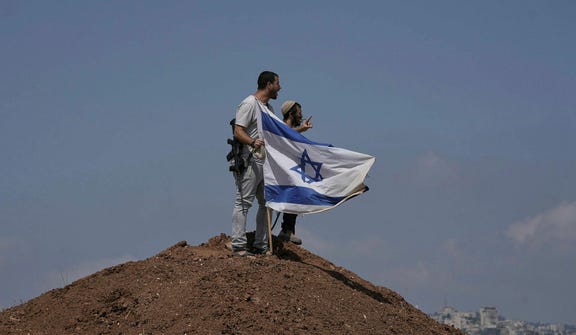 Israeli settlers on the outskirts of Beit Sahour in the West Bank on August 14. The economic repercussions of the Gaza war and surging settler violence are accelerating emigration from the West Bank.