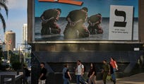 People walk past an election campaign billboard featuring National Security Minister Itamar Ben Gvir, leader of the Otzma Yehudit party, depicts handcuffed Palestinian prisoners, ahead of Israel's general election in Ramat Gan, Israel, Tuesday, Oct. 13, 2026. (AP Photo/Oded Balilty)