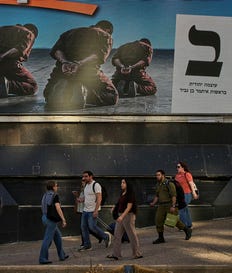 People walk past an election campaign billboard featuring National Security Minister Itamar Ben Gvir, leader of the Otzma Yehudit party, depicts handcuffed Palestinian prisoners, ahead of Israel's general election in Ramat Gan, Israel, Tuesday, Oct. 13, 2026. (AP Photo/Oded Balilty)
