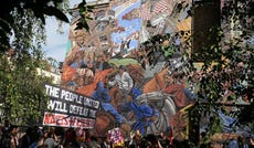 People march past the 'Cable Street' mural in Whitechapel, east London, on October 4, marking the 90th anniversary of the Battle of Cable Street.