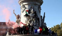 Protesters hold the French flag and the Palestinian flag as they stand on the statue of the Place de la Republique, Saturday. Credit: Jack Taylor/Reuters Protesters hold the French flag and the Palestinian flag as they stand on the statue of the Place de la Republique, Saturday.