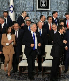 The ministers of Israel's 37th government walking away after having their photo taken, December 2022.