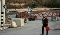 Palestinians cross on foot past a military gate closed to vehicles during an Israeli army operation in Hebron in the occupied West Bank on Saturday, a day after a Palestinian shooting attack in the area.