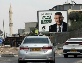 Cars driving by a poster for the United Arab List in southern Israel's Rahat, the largest Bedouin city, on Monday.